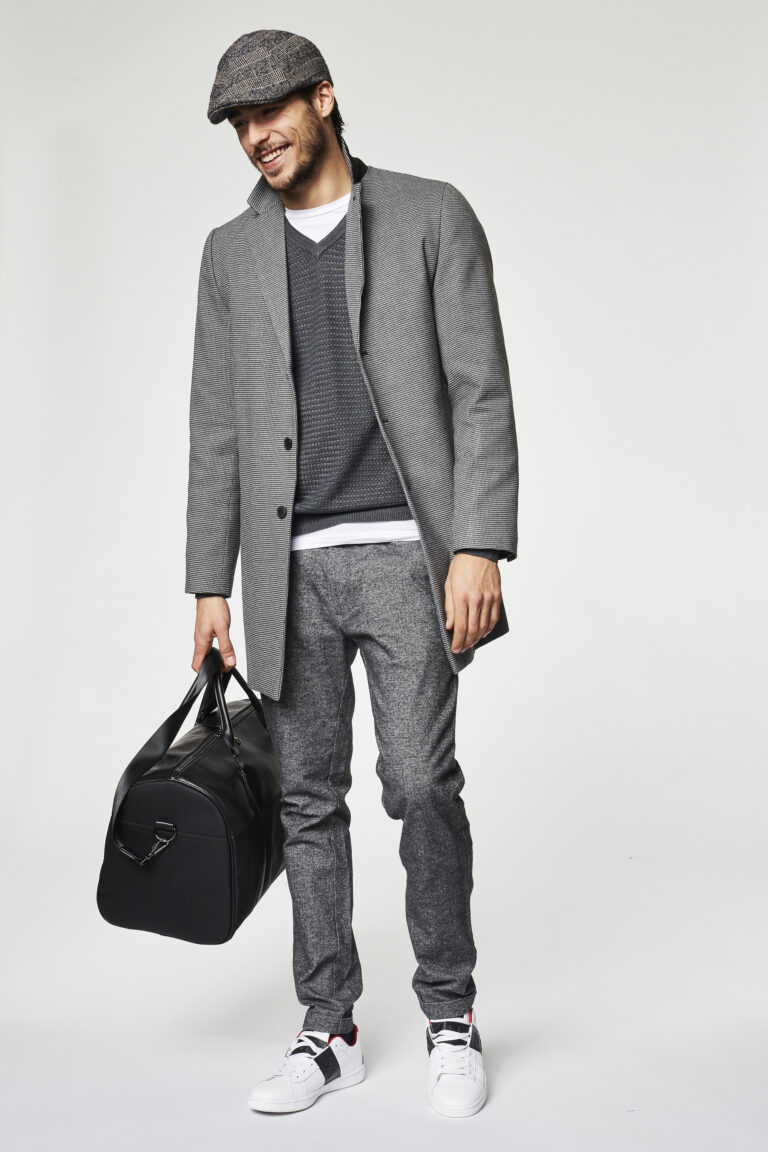 Gaudì Menswear FW20 lookbook: grey wool overcoat with flat cap, grey V-neck knit, wool trousers and black duffle bag – Leonardo Del Paggio, menswear designer